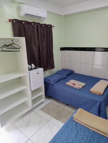 a small room with two beds and a closet at Edícula Planalto in Manaus