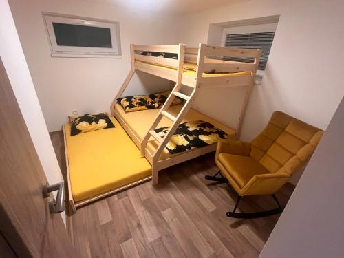 a room with two bunk beds and a chair at Chata pod loukou in Tvarožná Lhota