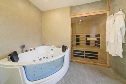 a large bathroom with a tub and a shower at Santo Wellness Villa by Mth in Santo António da Serra