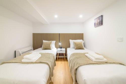 two twin beds in a room with white walls at Santo Wellness Villa by Mth in Santo António da Serra