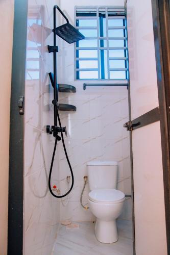 a bathroom with a toilet and a shower with a window at Dodoma Haven Homes in Dodoma