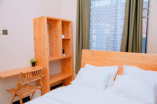 a bedroom with a bed and a desk and a window at Dodoma Haven Homes in Dodoma