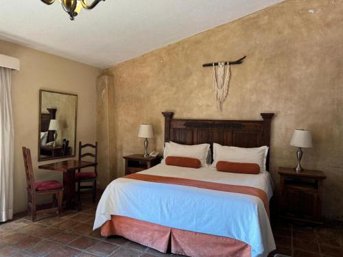 a bedroom with a bed and a desk and a chair at Cachito Mio hotel y temazcal in Cholula