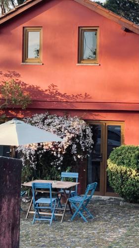 a table and chairs and an umbrella in front of a building at Casa de Margacide in Vila Nova de Cerveira
