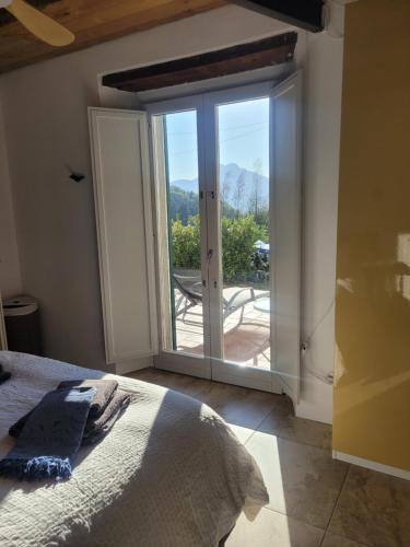 a bedroom with a bed and a sliding glass door at Villa Pavone in Coreglia Antelminelli