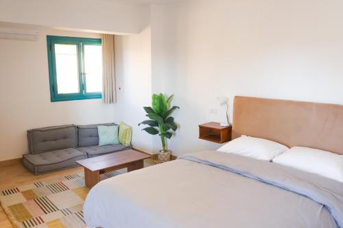 a bedroom with a bed and a couch at Rafiki Hostels - Pyramids in Giza