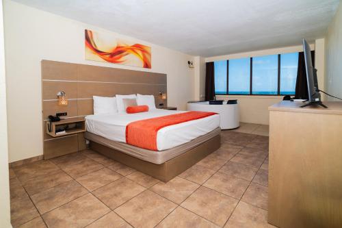 a bedroom with a bed and a flat screen tv at Hotel El Guajataca in Quebradillas