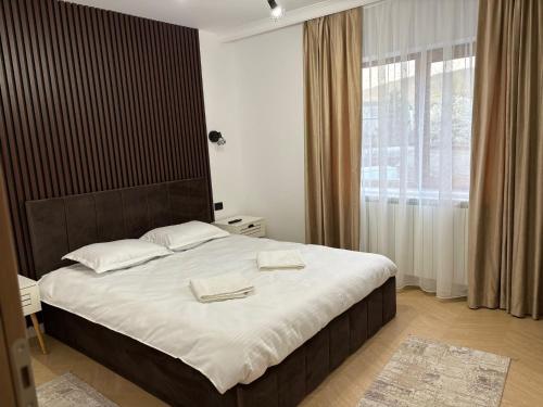 a bedroom with a large bed with two towels on it at Borșa ApartHotel 5 in Borşa