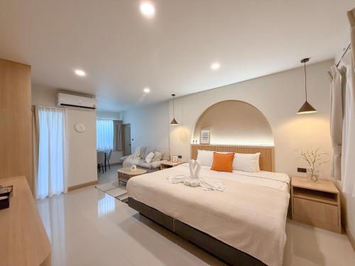 a bedroom with a large bed and a living room at Abundant Eco Hostel in Laguna Phuket
