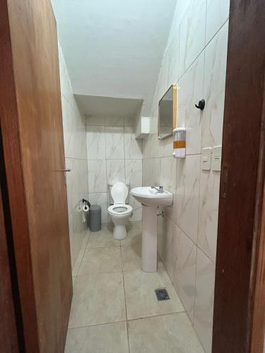 a bathroom with a toilet and a sink at Duplex NR in Nu Guazu