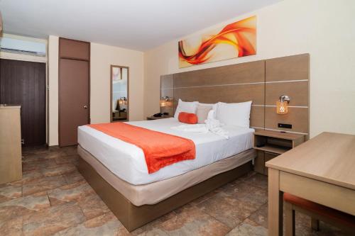 a hotel room with a bed and a desk at Hotel El Guajataca in Quebradillas