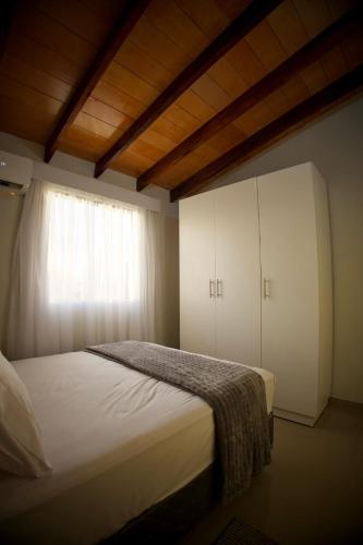 a bedroom with a white bed and a window at Duplex NR in Nu Guazu