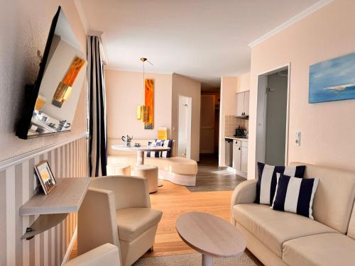 a living room with a couch and a table at Suiten-Hotel mare Langeoog in Langeoog