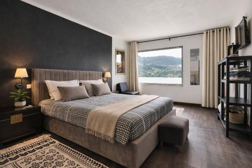 a bedroom with a large bed and a large window at Quinta do Regato Douro in Penafiel