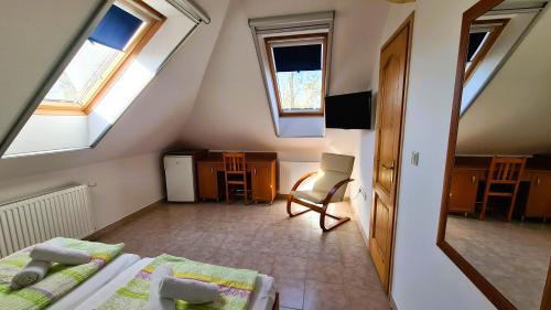 a attic room with two beds and a chair at Rider Beach in Balatonszemes