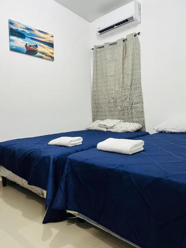 a bedroom with a bed with blue sheets and a window at Casa Verde in San Miguel