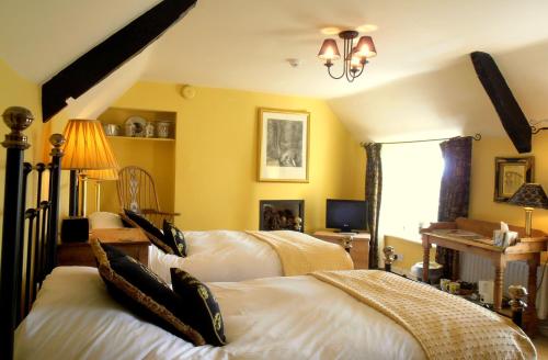 a bedroom with two beds and a chandelier at The Hunters Rest Inn in Clutton