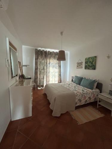 a bedroom with a white bed and a window at Mel&Laranja in Alvor