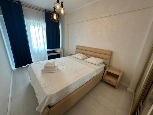 a small bedroom with a bed with white sheets at Fancy Bonjour - modern apartment in Iaşi