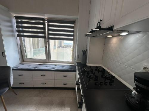 a kitchen with a window seat next to a stove at Fancy Bonjour - modern apartment in Iaşi