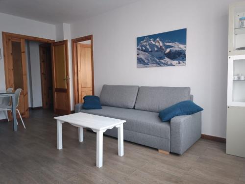 a living room with a couch and a table at Apartamento Tilero, Parking incluido in Jaca