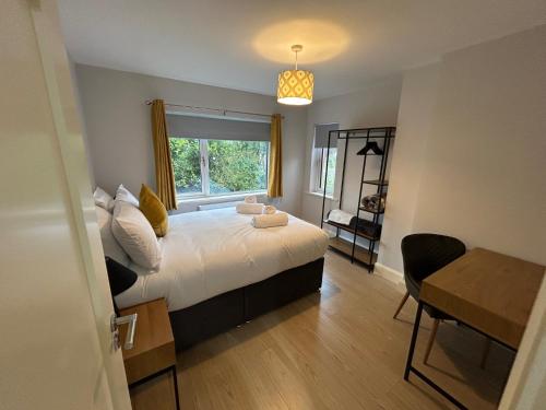 a bedroom with a bed with a window and a table at Colony Retreat in Dingle
