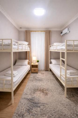 a bedroom with two bunk beds and a rug at Hostel DANEXAN APA in Nukus