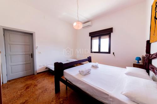 a room with two beds and a window and a door at Villa Oasis in Torre Lapillo
