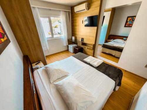 ein Schlafzimmer mit einem großen Bett in einem Zimmer in der Unterkunft Torre Sol Hotel & Eventos in Balneário Camboriú