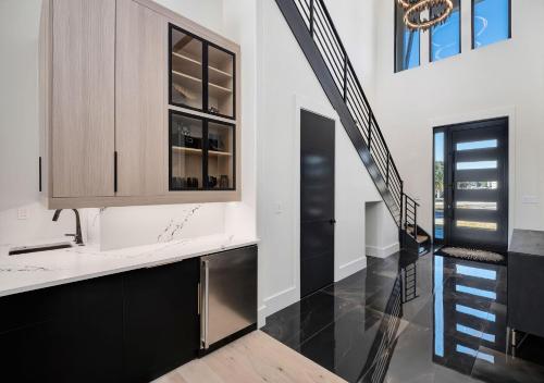 a kitchen with black cabinets and a staircase at Isle Be Back in Destin