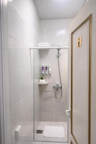 a shower with a glass door in a bathroom at Hostel DANEXAN APA in Nukus