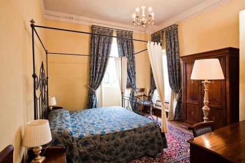 1 dormitorio con cama, escritorio y cortinas en Castello Montegiove, en Fano