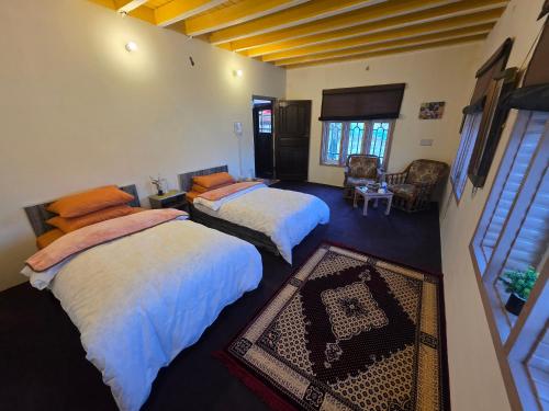 a bedroom with two beds and a living room at Cottage De Hunza- A Soul Retreat Sanctuary in Hunza Valley