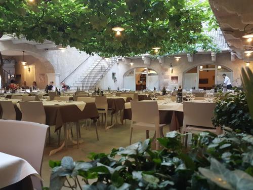 a dining room with tables and chairs and plants at Casa Alla Lega in Arco