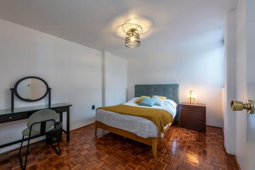 a bedroom with a bed and a desk and a mirror at Departamento en Coyoacán 8 in Mexico City