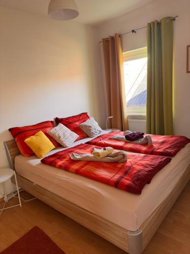 a bedroom with a large bed with a red blanket at ApartmentRegina, renoviert! in Knittelfeld