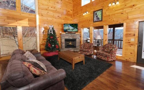 a living room with a couch and a christmas tree at Lovely Platog Chalet with jacuzzi in Morzine