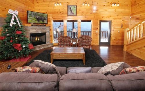a living room with a couch and a christmas tree at Lovely Platog Chalet with jacuzzi in Morzine