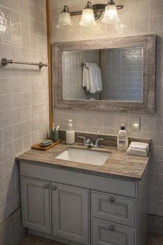 a bathroom with a sink and a mirror at Augustus Jane Inn in Rocky Harbour