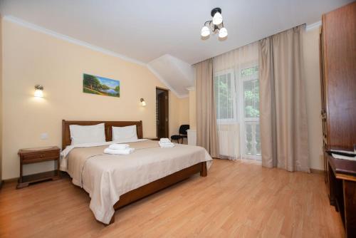 a bedroom with a large bed and a television at Сонячна Квітка in Polyana