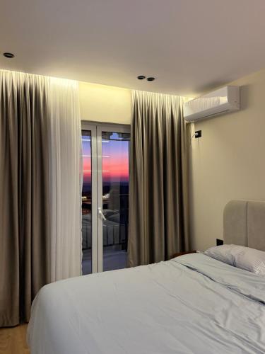a bedroom with a bed and a window with a view at FIN Skyline Apartment in Krujë