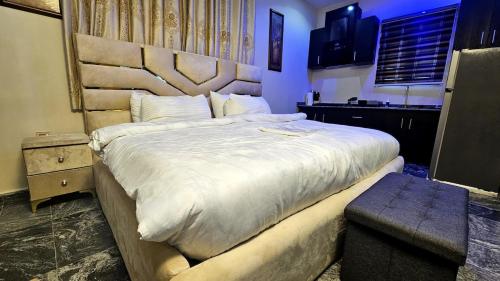 a bedroom with a large bed with a wooden headboard at Skye Palace Apartment - Ambassador Suite in Akure