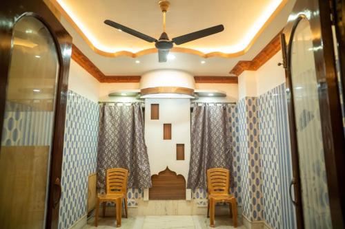 a hallway with chairs and a ceiling fan at The Tulsi Enclave Riverside in Agartala