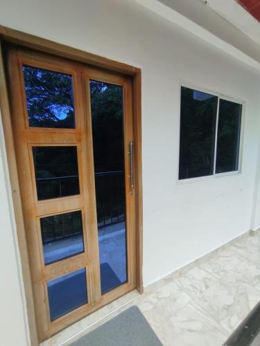 a wooden door with a window in a room at Minca nomada 517 de la sierra in Santa Marta