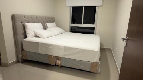 a bed in a small room with a window at Premium Apartamento en Lambare in Asunción