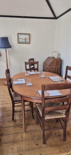 a wooden dining room table with chairs and a lamp at Spout House Studio in Boldre
