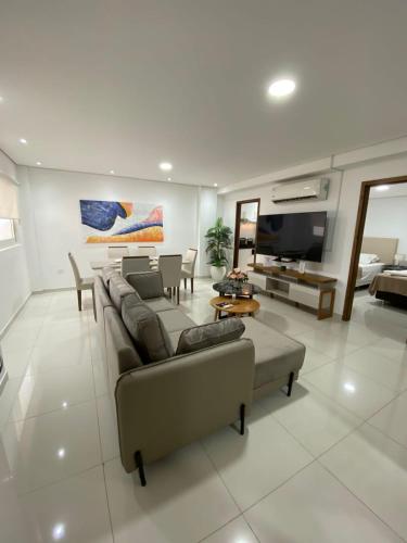 a living room with a couch and a tv at Edificio Juan XXIII - 2 Dormitorios - Zona Shopping Del Sol in Asunción