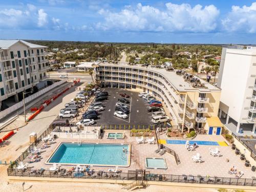an aerial view of a hotel with a pool and a parking lot at Outrigger Beach Club Resort by CoolVacay in Ormond Beach