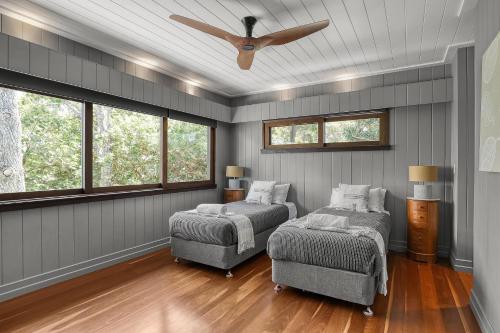 a bedroom with two beds and a ceiling fan at Dolphins at Sunset in Amity Point