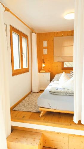 a bedroom with a white bed and a window at Boutique Loft "Mrs Green" im Thayatal, Tiny Haus in Drosendorf Stadt